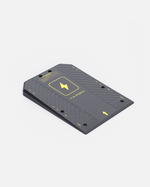 Dark grey textured docking station by JARBO with a ramped design, yellow lightning symbol, and an arrow.